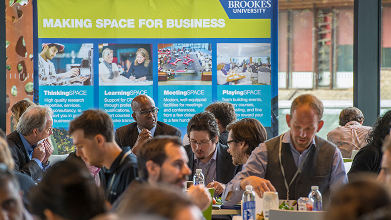 People talking in front of a 'Making space for business' poster